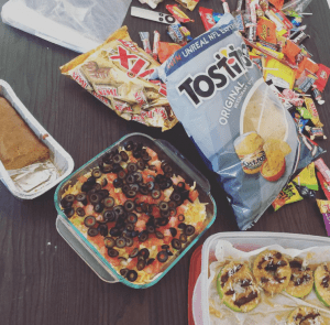 office food spread including candy, chips, dip, and other snack