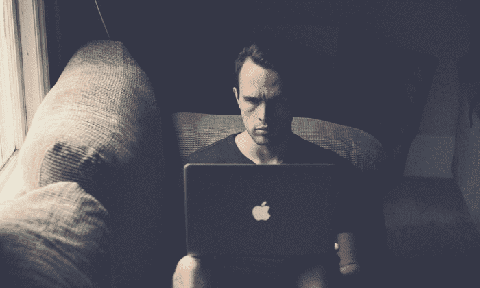 man unhappy looking at laptop